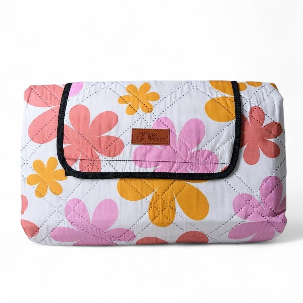 retro floral picnic rug folded neatly on a white background, showing compct design and floral pattern